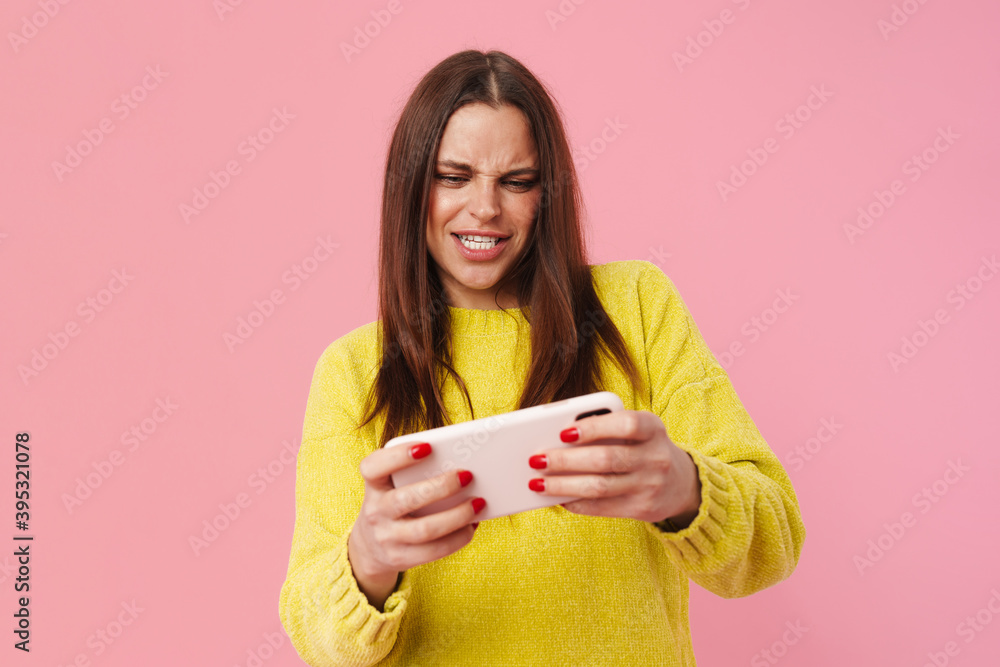 Excited brunette girl playing online game on mobile phone Excited brunette girl playing online game on mobile phone
