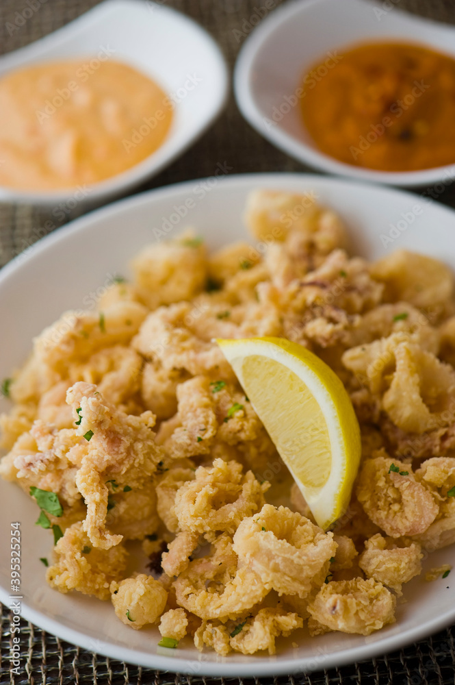 Calamari served with spicy and sweet dipping sauces. Classic American restaurant or French bistro appetizer favorite. Fresh octopus, squid and shrimp battered and deposed fried.