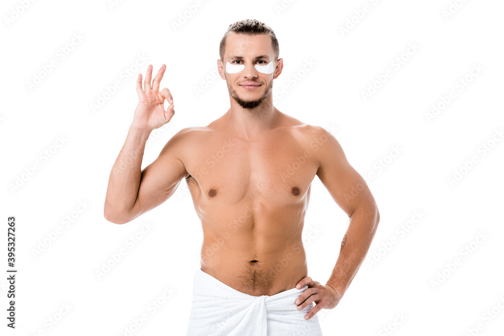 shirtless man in towel with eye patches on face showing ok isolated on white shirtless man in towel with eye patches on face showing ok isolated on white
