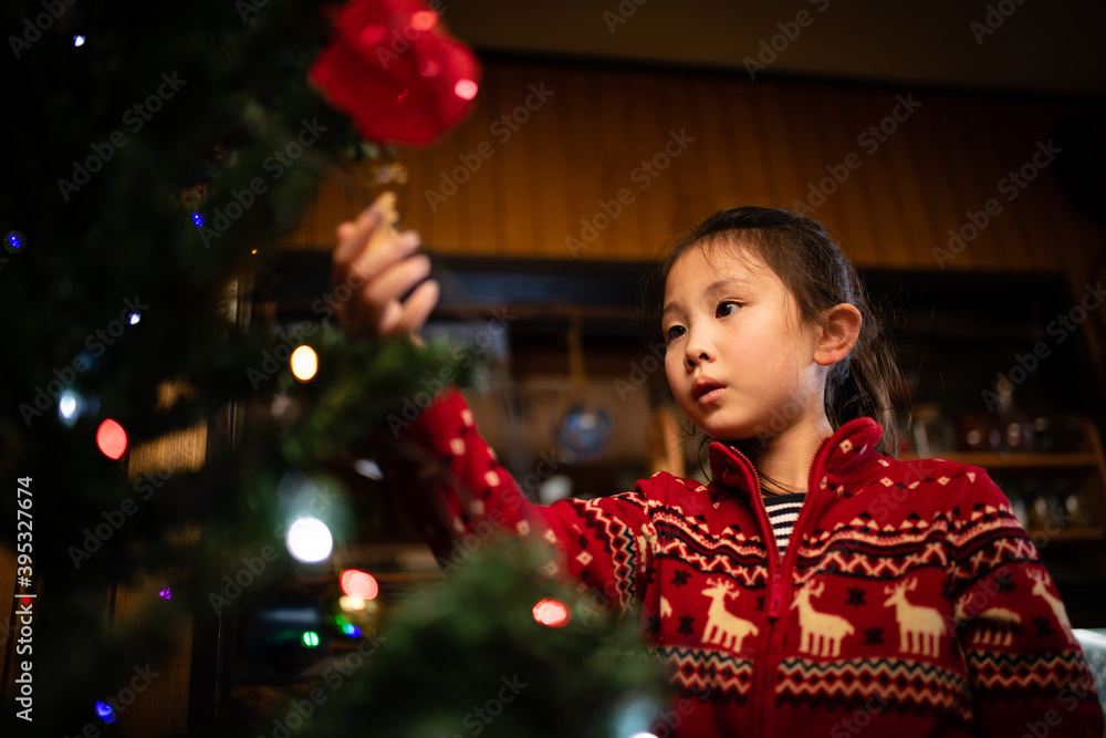 クリスマスツリーの飾りつけをする少女 クリスマスツリーの飾りつけをする少女