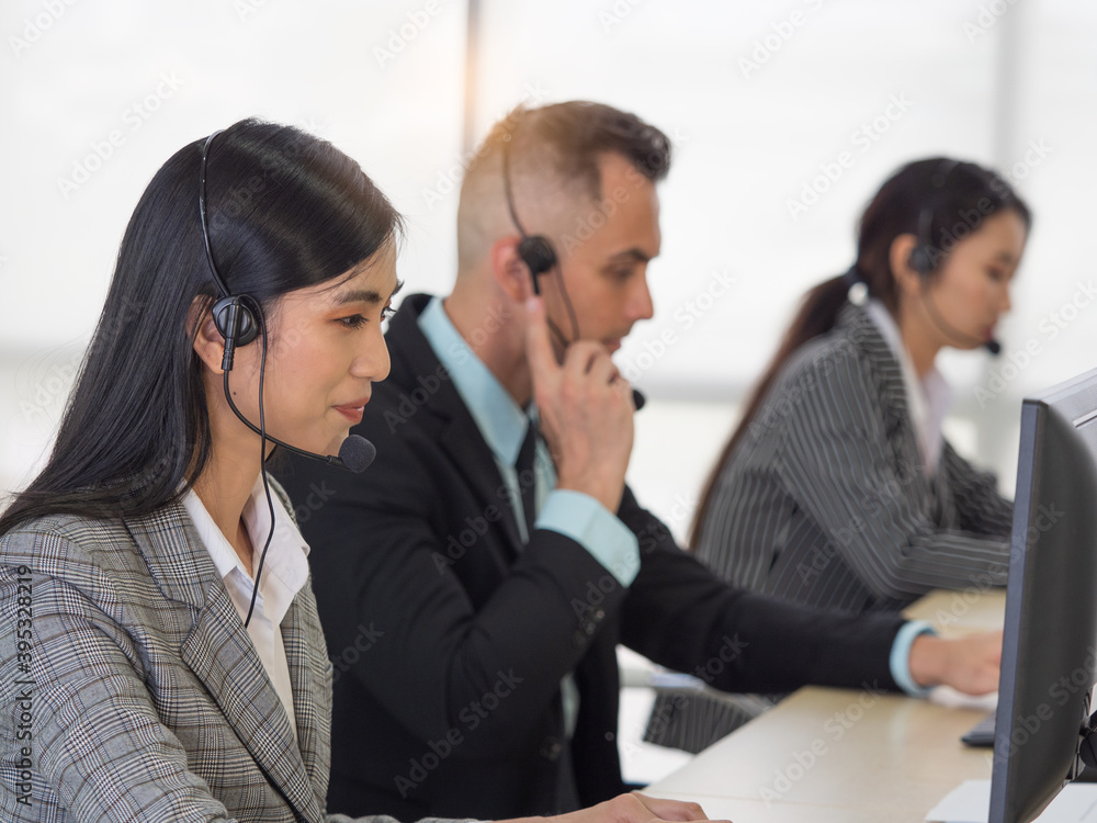 Selective focus, on Asian customer survice woman or callcenter with blurry image of the team. Selective focus, on Asian customer survice woman or callcenter with blurry image of the team.
