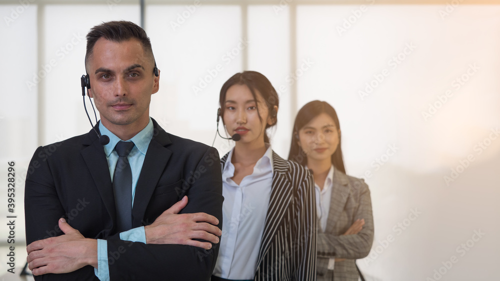 Selective focus, Caucasian man with headset standing in row with colleague. Call Center or Customer Service team. Selective focus, Caucasian man with headset standing in row with colleague. Call Center or Customer Service team.