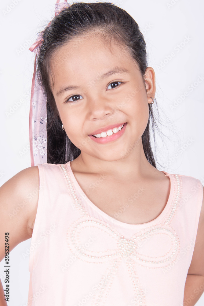 Portrait of cute casual smiling asian girl 8-9 year old posing and looking at camera isolated on light background. Laughing people. Positive emotions. Childhood concept. Portrait of cute casual smiling asian girl 8-9 year old posing and looking at camera isolated on light background. Laughing people. Positive emotions. Childhood concept.