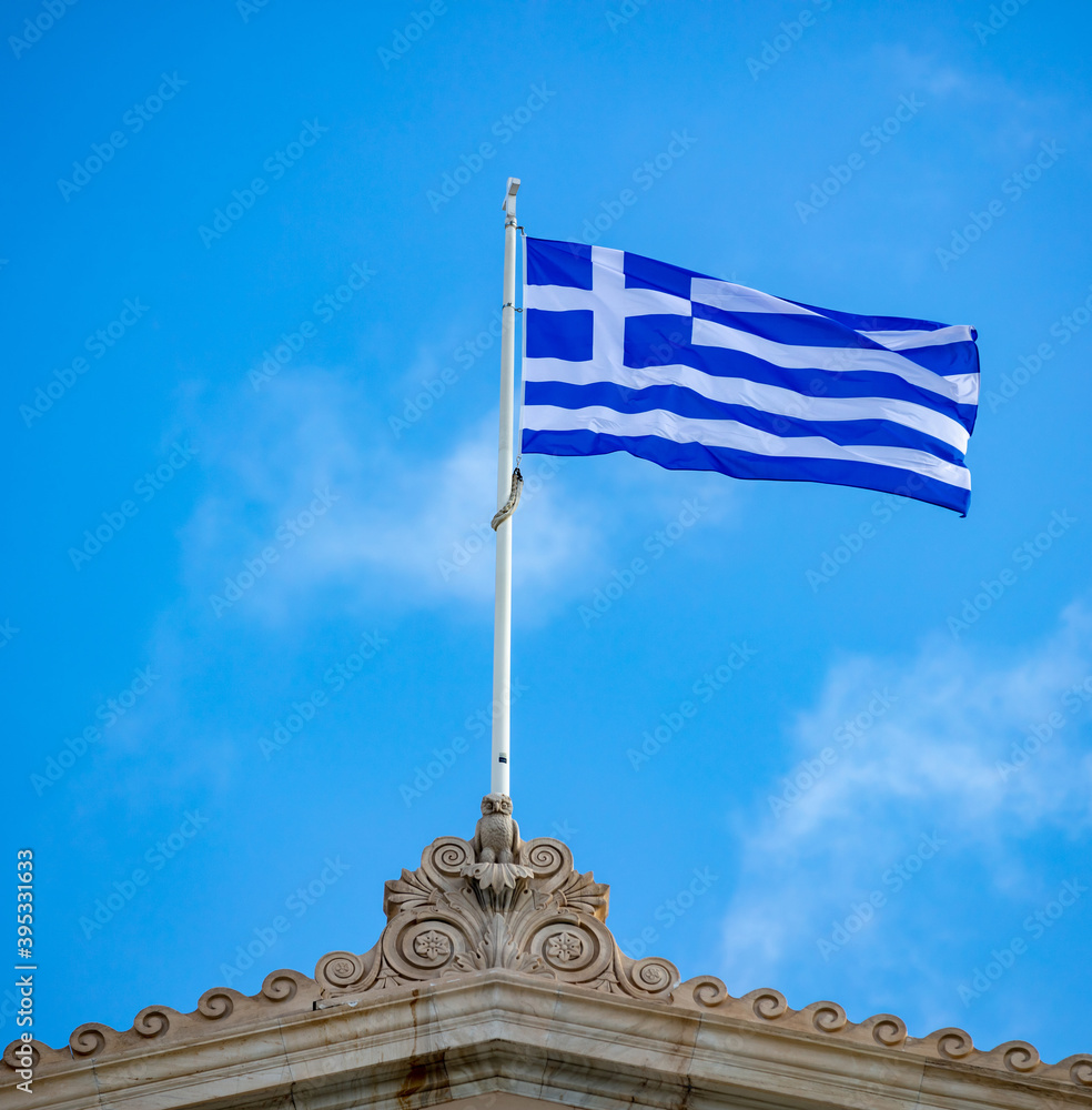 Greek flag waving against blue sky background.