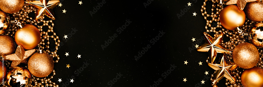 Christmas and New Year banner with copy space. Golden balls and stars on black backdrop.