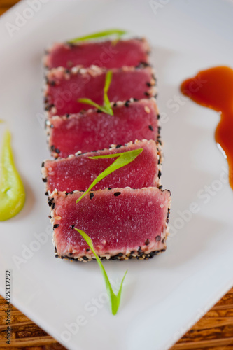 Ahi tuna, pan sesame seared rare. Premium sushi grade tuna seared and served with avocado, cucumber, caviar, ginger, wasabi and soy. Classic fine dining appetizer.