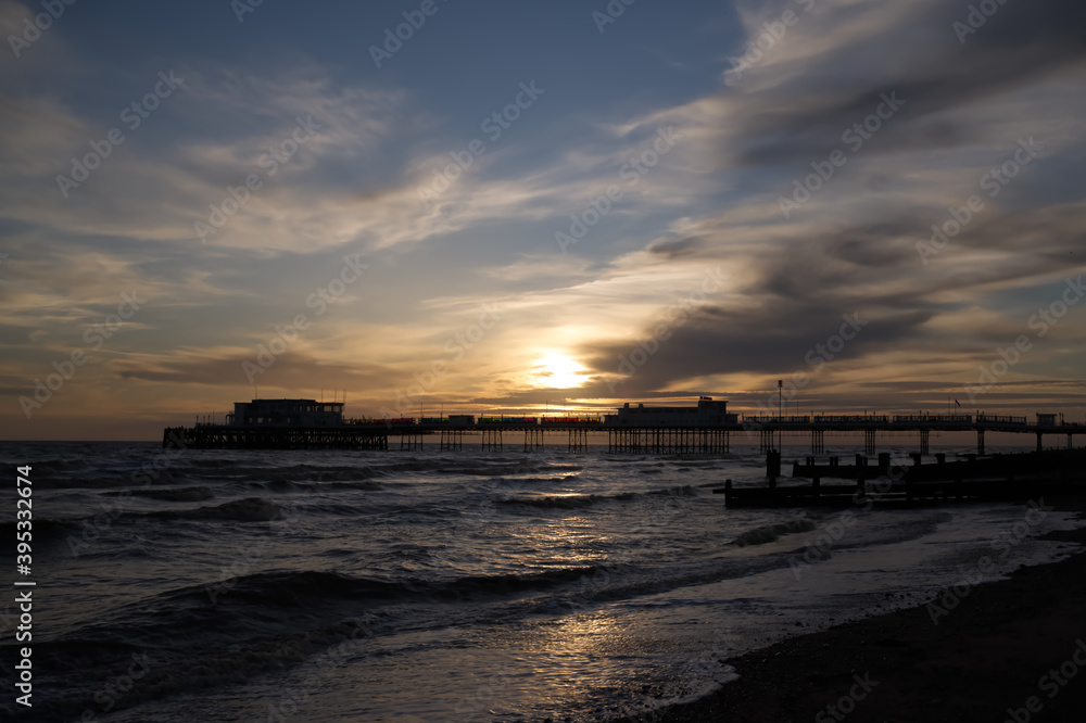 Naklejka premium Dramatic sunset over the pier on Worthing seafront.