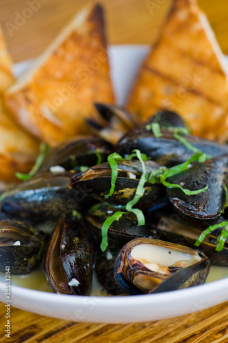 Mussels. Steamed mussels simmered with butter, garlic, shallots, red wine, tarragon, salt and pepper and served with toasted baguettes. Classic French bistro appetizer.
