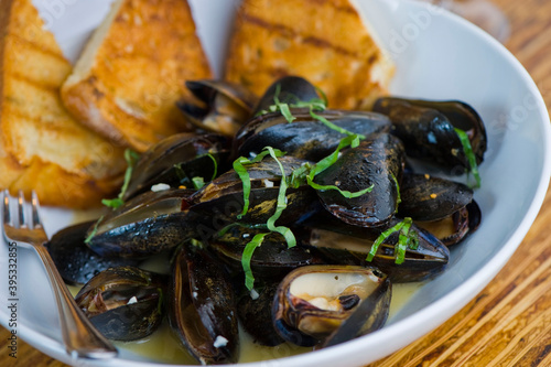 Mussels. Steamed mussels simmered with butter, garlic, shallots, red wine, tarragon, salt and pepper and served with toasted baguettes. Classic French bistro appetizer.