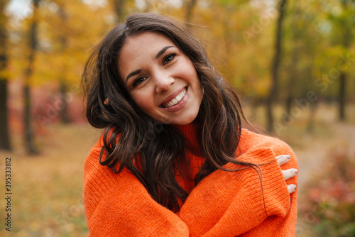 Obraz na plátně Beautiful brunette happy woman smiling while strolling in autumn forest