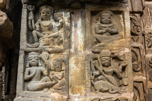 Naggar, Himachal Pradesh, India - June 2012: Ornate stone carvings on the walls of an ancient Hindu temple in the Kullu valley.
