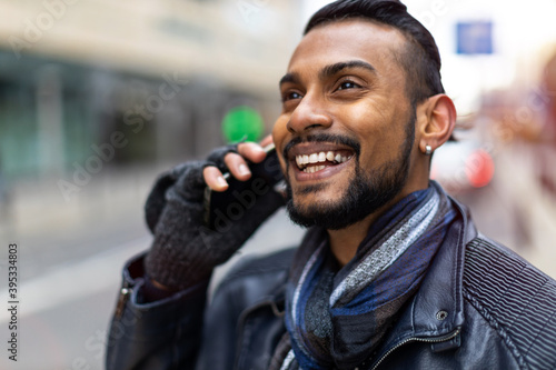 Portrait of a handsome young man using mobile phone at the street
