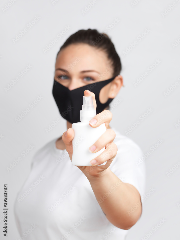 Young woman with mask holding a sanitizer spray Young woman with mask holding a sanitizer spray