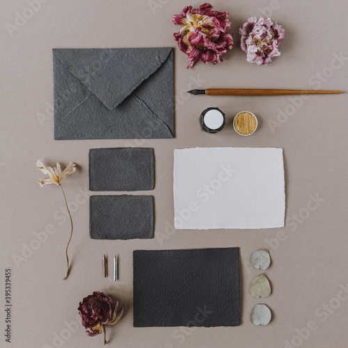 Flat lay empty blank paper card, envelope, pen, flower buds on beige background. Wedding invitations cards. Flatlay, top view copy space collage. Template for blog, website, social media. photo