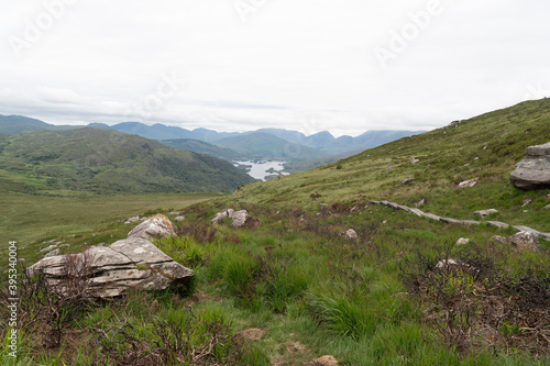 Panoramic view of the Irish countryside with trees, green vegetation and lakes with mountains and hills, cloudy day in Ireland