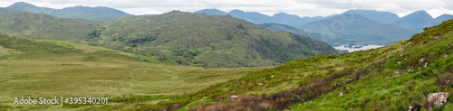 Irish countryside landscape. Valley, lakes, river and mountains in background. Panoramic, majestic unique view, vivid powerful colors. Part of Wild Atlantic Way. Travel magazine cover concept