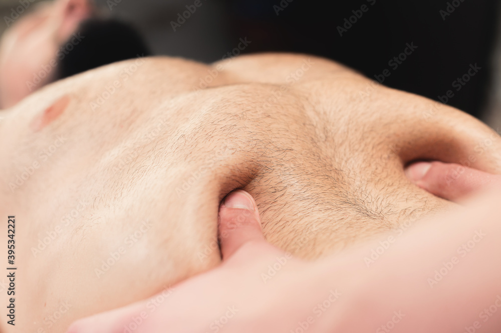 Close-up massage and positioning of the abdomen and internal organs and diaphragm of the abdominal cavity of a man - obrazy, fototapety, plakaty 
