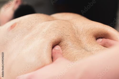 Close-up massage and positioning of the abdomen and internal organs and diaphragm of the abdominal cavity of a man photo