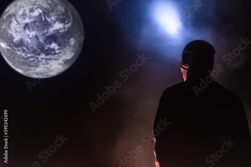 Man with a lantern looks at the planet