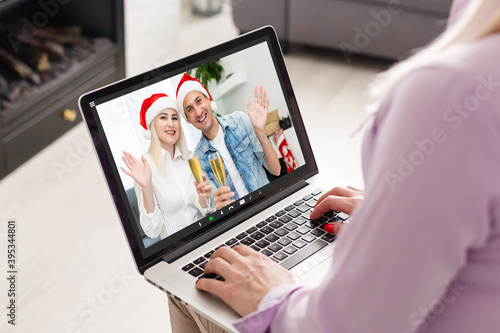 Caucasian woman at christmas, having video chat with friends and family using laptop. social distancing during covid 19 pandemic at christmas time.