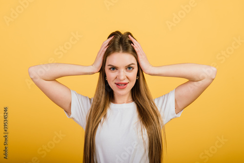 Isolated portrait of happy woman stands over yellow wall. Positive emotions and feelings concept