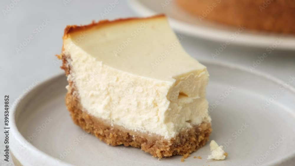 Slice of new york cheesecake. Taking bite of cheesecake with a fork Slice of new york cheesecake. Taking bite of cheesecake with a fork