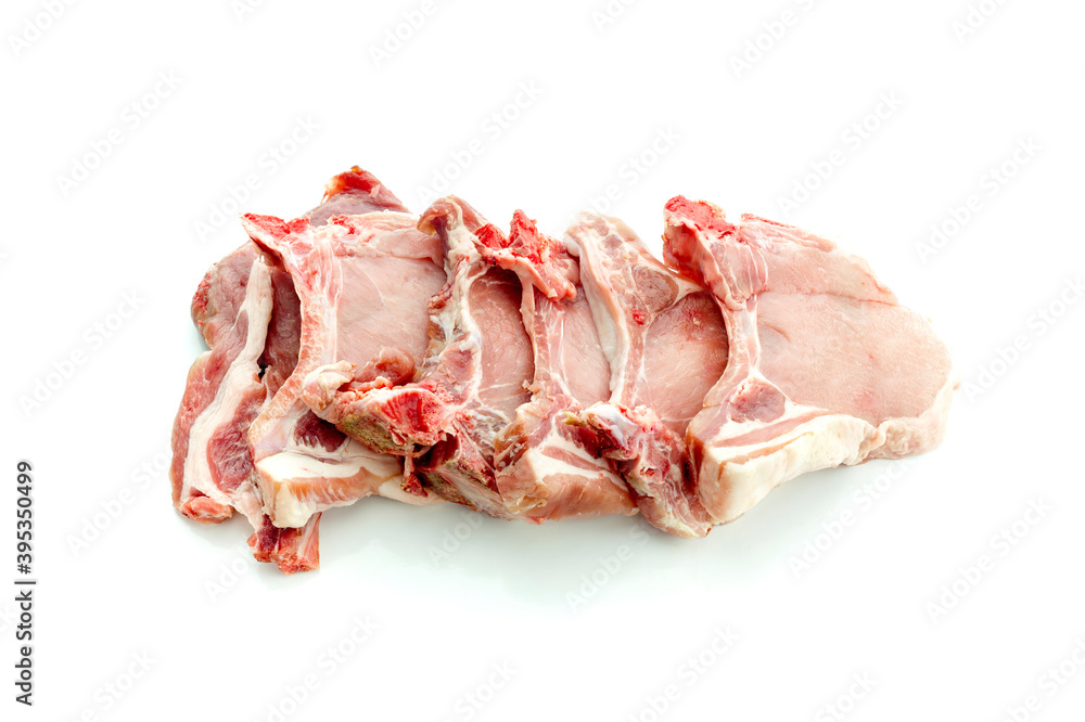 The fresh, raw pieces of pork on a white background close-up The fresh, raw pieces of pork on a white background close-up