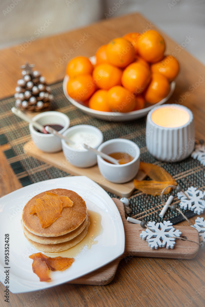 Festive table setting with vegane pancakes and tangerines Festive table setting with vegane pancakes and tangerines