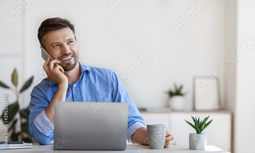 Handsome Male Entrepreneur Having Phone Conversation And Drinking Coffee At Workplace