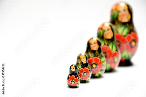 A set of Russian nesting dolls lined up in one row. The smallest is in front and the largest is behind and is a little blurry.
