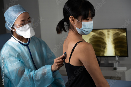 Consultation d'une patiente chez le médecin généraliste, auscultation poumons. photo