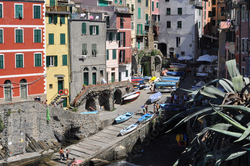 View of Cinque Terre Village with plants, buildings, sea boats and people