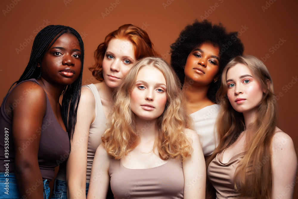 Obraz premium young pretty caucasian, afro, scandinavian woman posing cheerful together on brown background, lifestyle diverse nationality people concept