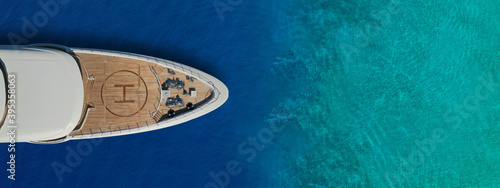 Aerial drone ultra wide panoramic top view photo of large yacht - boat with helicopter landing area anchored in tropical exotic paradise bay with turquoise open sea © aerial-drone