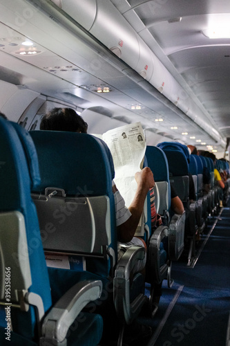 Airplane interior man reading paper