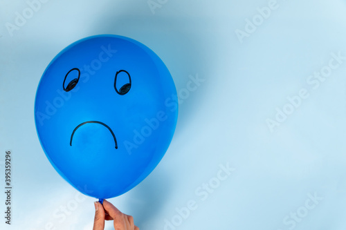 A sad Blue Monday emoticon is drawn on a hot air balloon on a blue background.