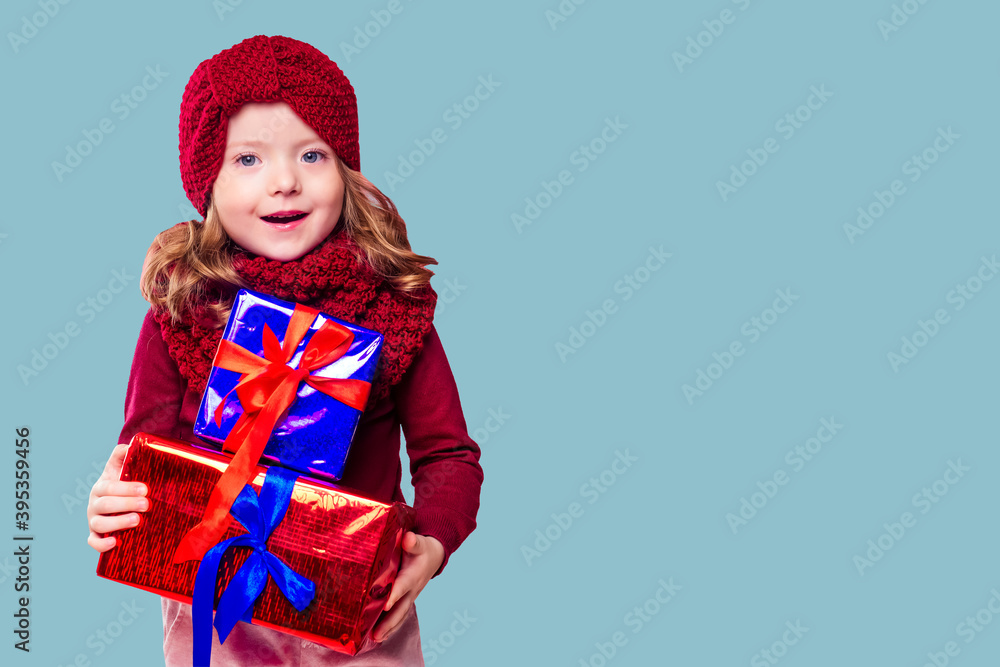 Beautiful blone little girl in the winter warm hat and scarf feeling happy and wish a good things on a Christmas Beautiful blone little girl in the winter warm hat and scarf feeling happy and wish a good things on a Christmas