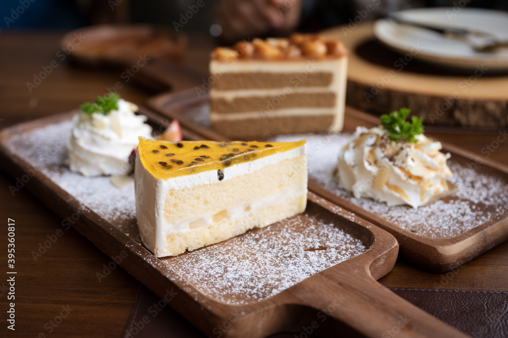 Passion fruit cake with vanilla layer, whipped cream and icing on wooden tray