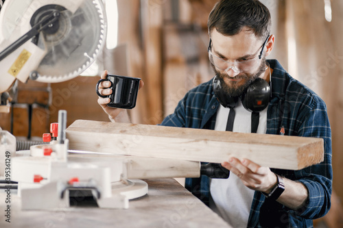 Wood cutting with circular saw. Closeup of mature man sawing lumber.