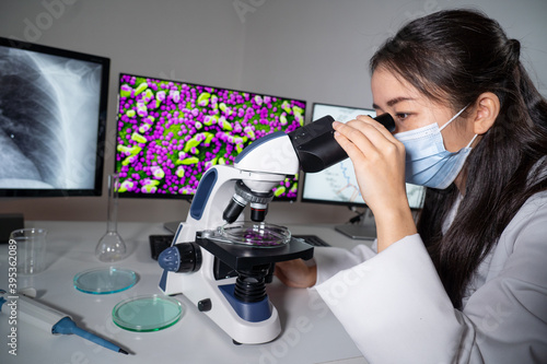 Femme asiatique utilisant un microscope et imagerie médicale de virus.