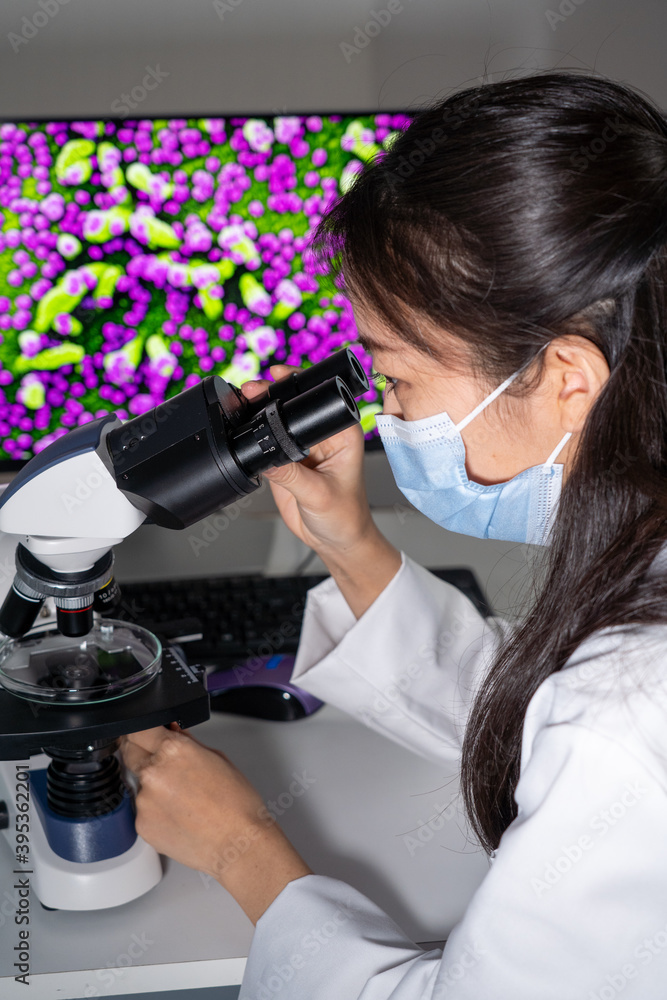 Fototapeta premium Femme asiatique utilisant un microscope et imagerie médicale de virus.