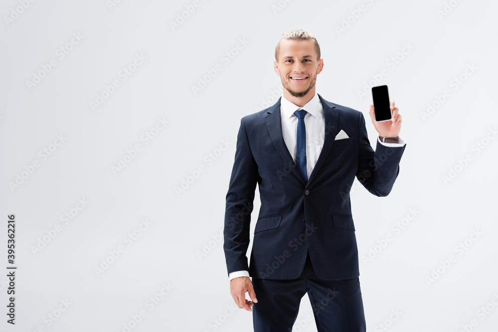 young businessman in suit presenting smartphone isolated on white young businessman in suit presenting smartphone isolated on white