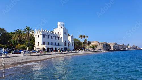 Kos Town Police Station and castle overlook a pebble beach on Kos Island.