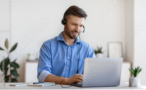 Handsome Young Man In Headset Study Online, Watching Webinar On Laptop photo