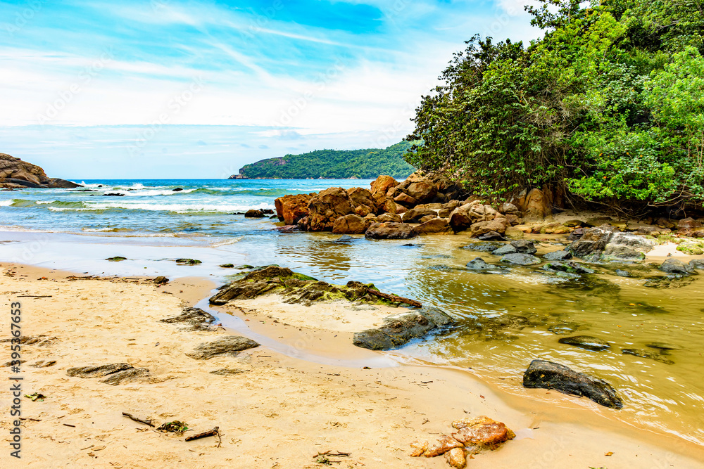 River flowing into the beach between the sea, the rocks and the rainforest in Trindade coastal south of the state of Rio de Janeiro River flowing into the beach between the sea, the rocks and the rainforest in Trindade coastal south of the state of Rio de Janeiro