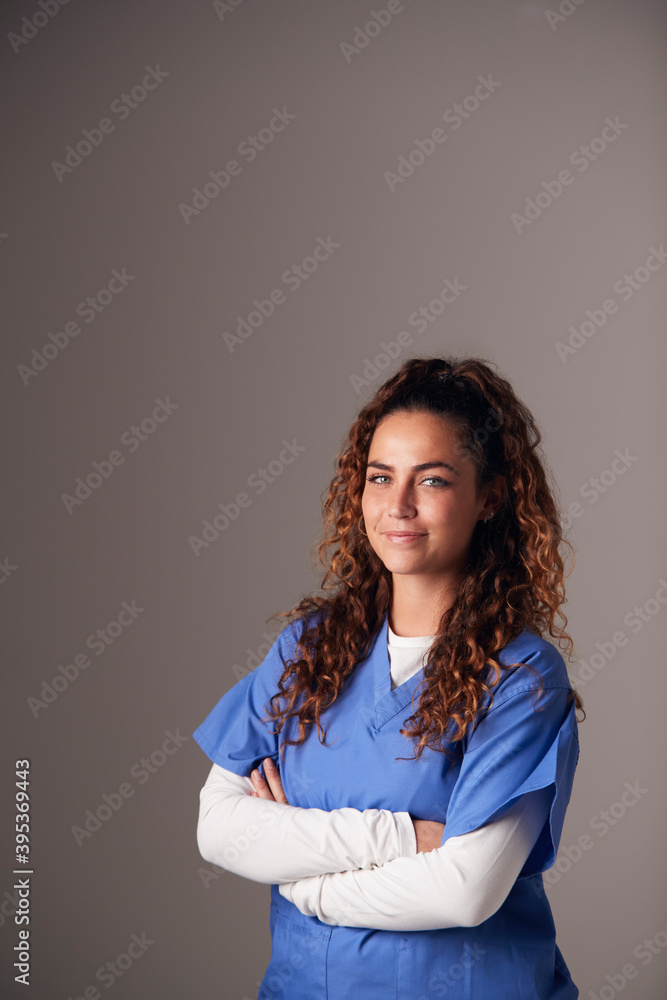 Studio Portrait Of Young Female Nurse Wearing Scrubs Standing Against Grey Background Studio Portrait Of Young Female Nurse Wearing Scrubs Standing Against Grey Background