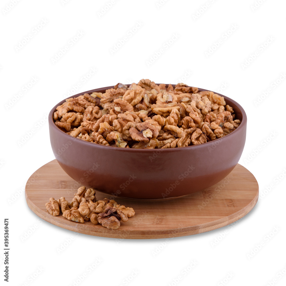 Walnuts in brown bowl on wood board isolated on white background, copy space.