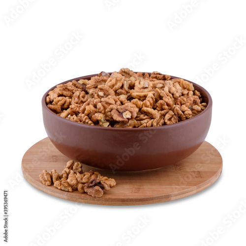 Walnuts in brown bowl on wood board isolated on white background, copy space.