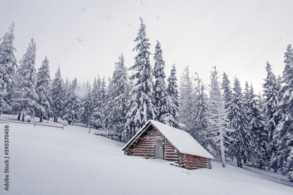 Fantastic winter landscape with wooden house in snowy mountains. Christmas holiday concept. Carpathians mountain, Ukraine, Europe Fantastic winter landscape with wooden house in snowy mountains. Christmas holiday concept. Carpathians mountain, Ukraine, Europe
