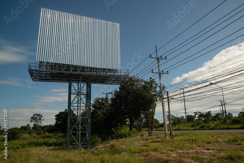 Blank billboard on the background of the road and blue sky. photo